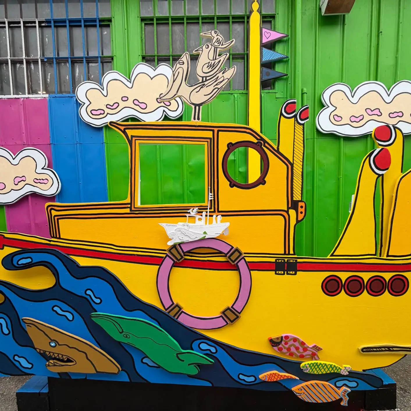 the bright yellow Miss Adventure II fishing boat mural displayed alongside other colorful street art installations at Umbrella Alley in San Francisco.